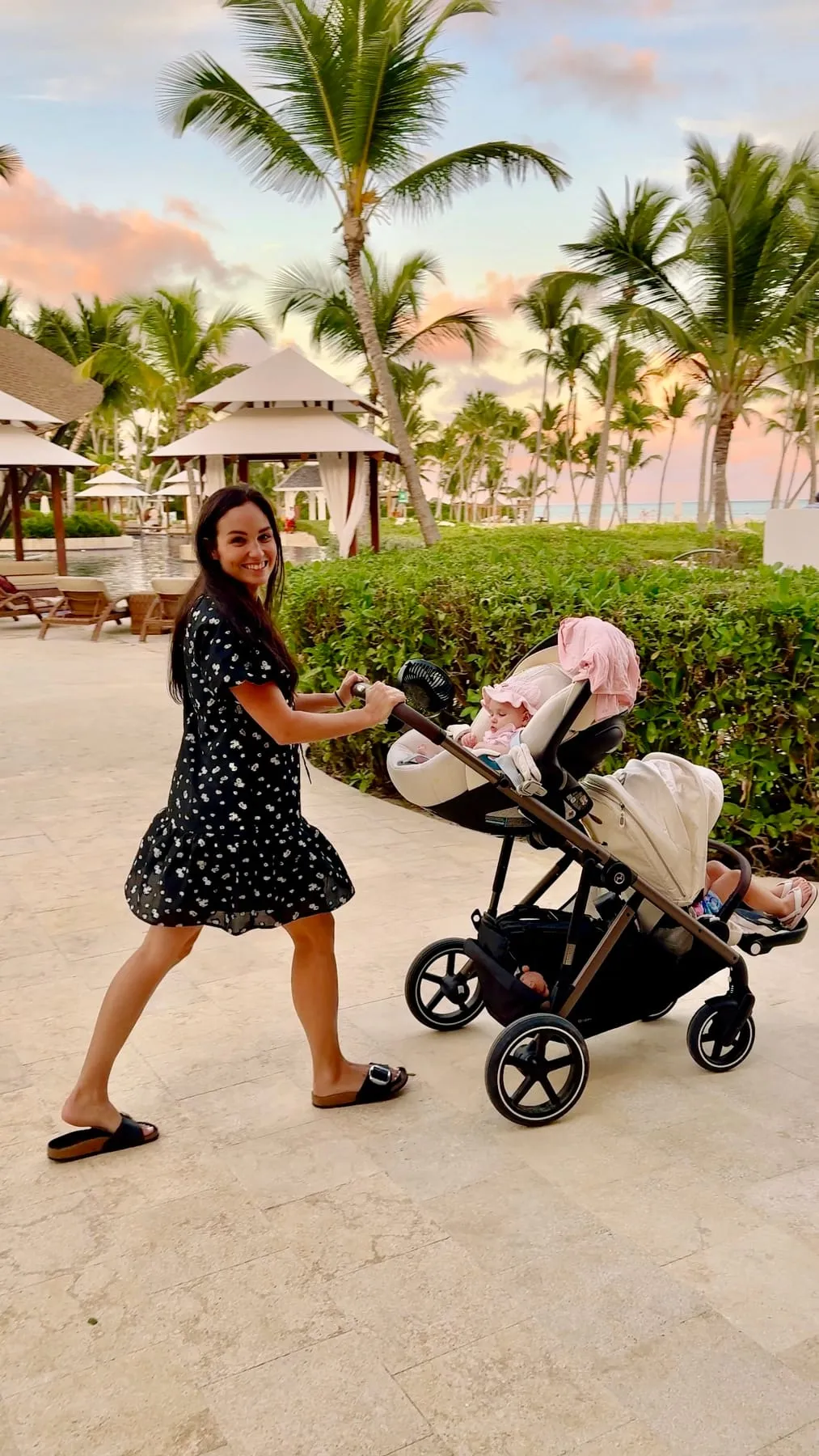 Kiersten pushing the Cybex Gazelle double stroller along a palm-lined resort path