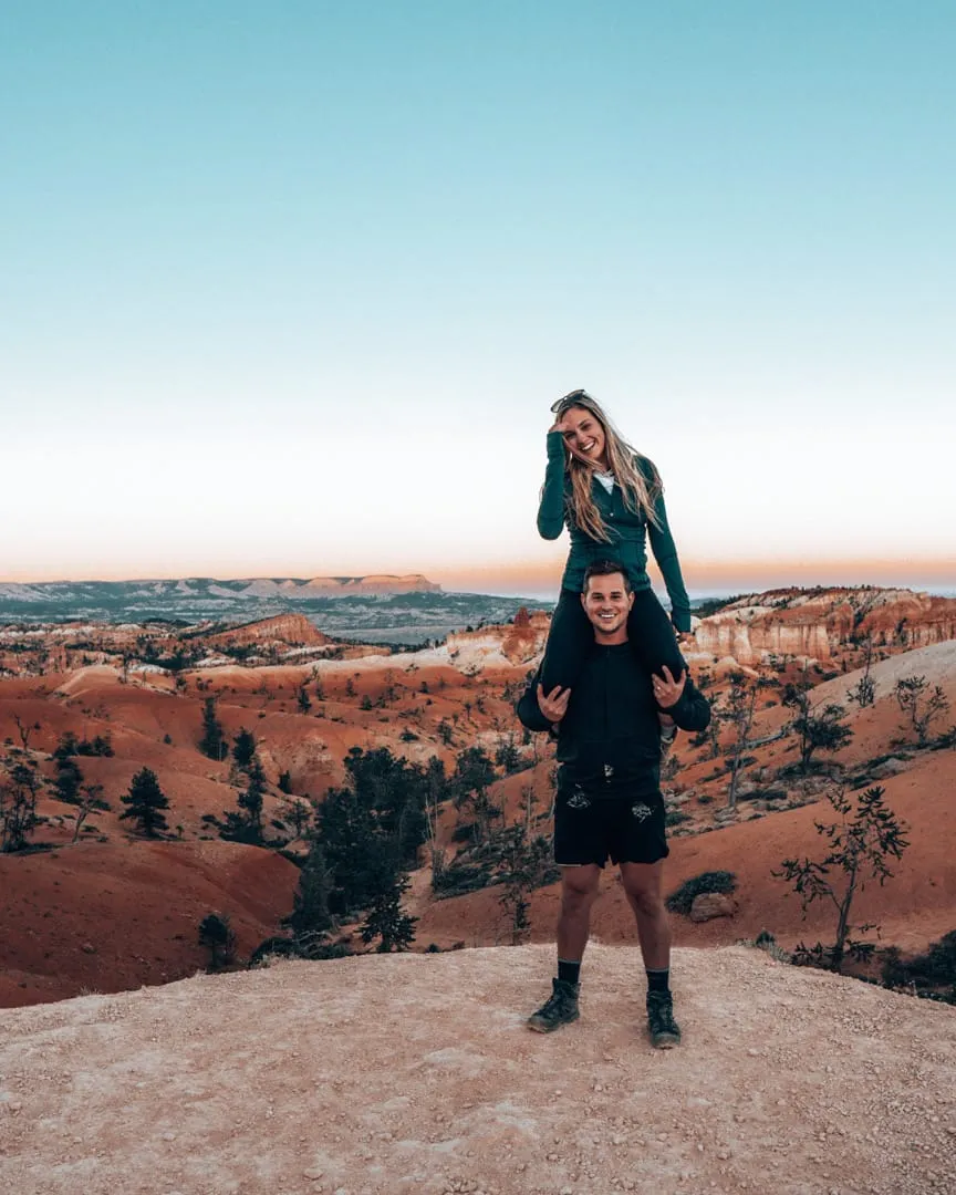 Kiersten on Ryan's shoulders at a Bryce Canyon overlook at dusk