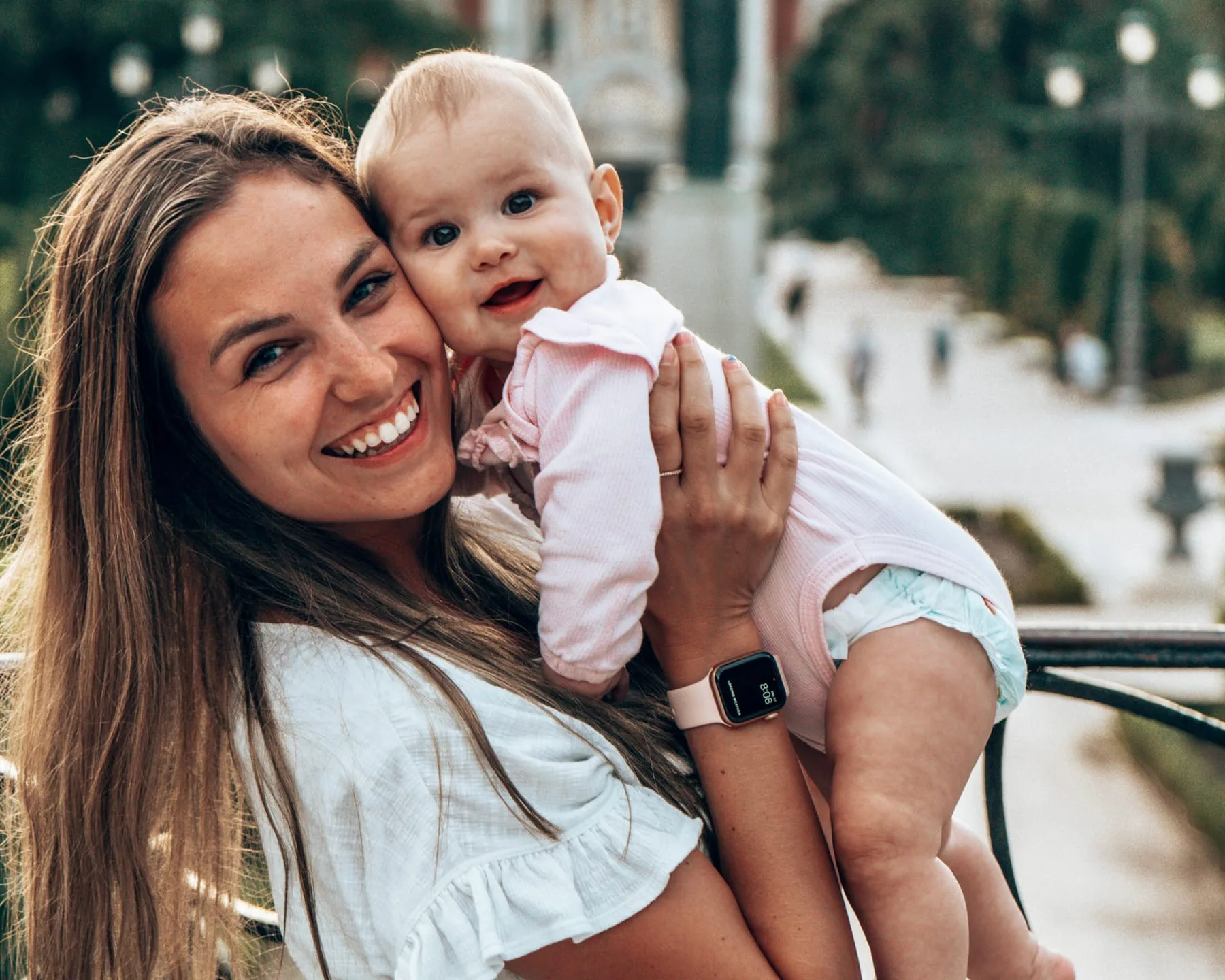Kiersten cheek to cheek with baby Addie on a city street