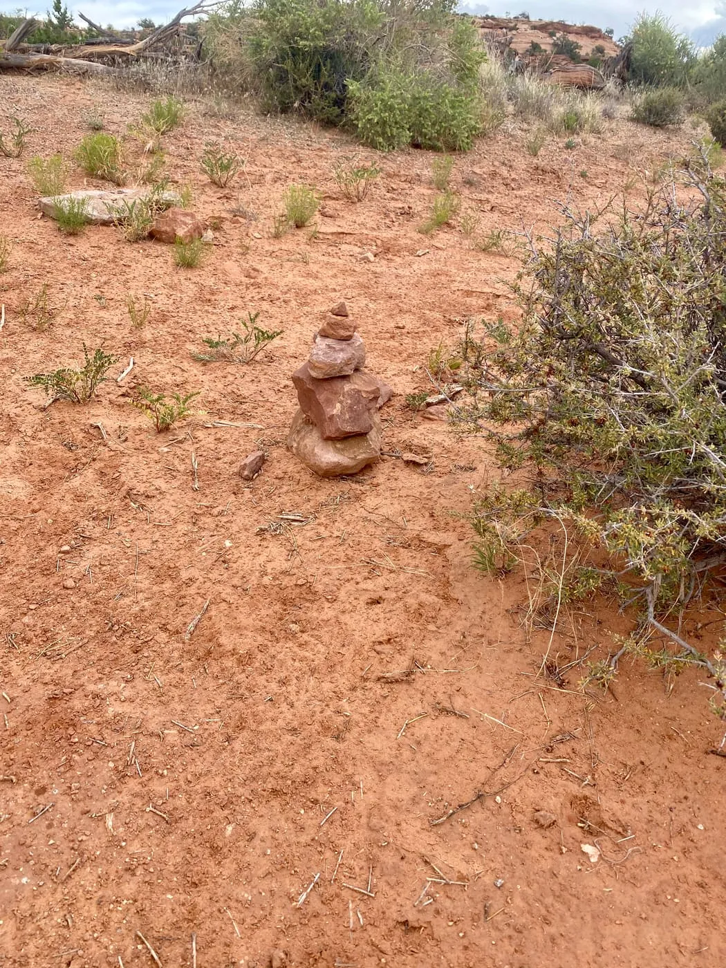 A small rock cairn marking the trail through the red dirt