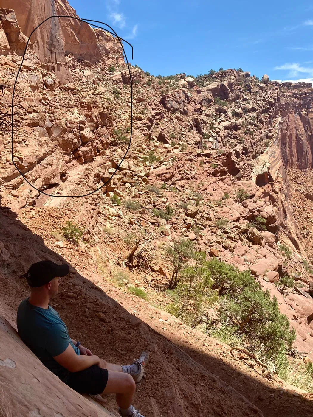 Ryan sitting in the rock alcove at the False Kiva archaeological site