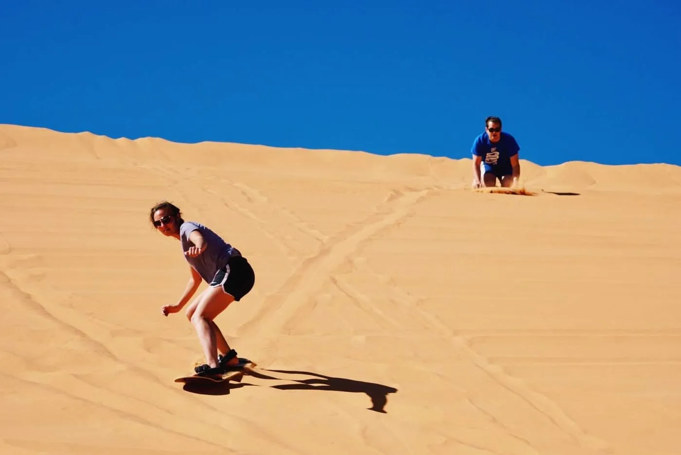 Sandboarding down a dune at Coral Pink Sand Dunes